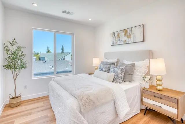 a bedroom with bed and a potted plant