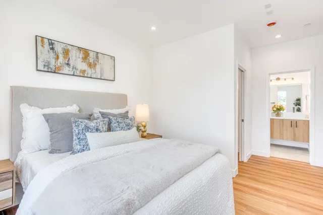 a bedroom with a bed and a painting on the wall