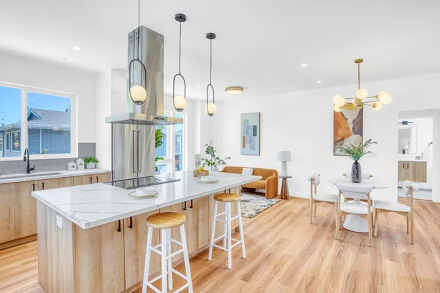 an open kitchen with granite countertop a table and chairs in it