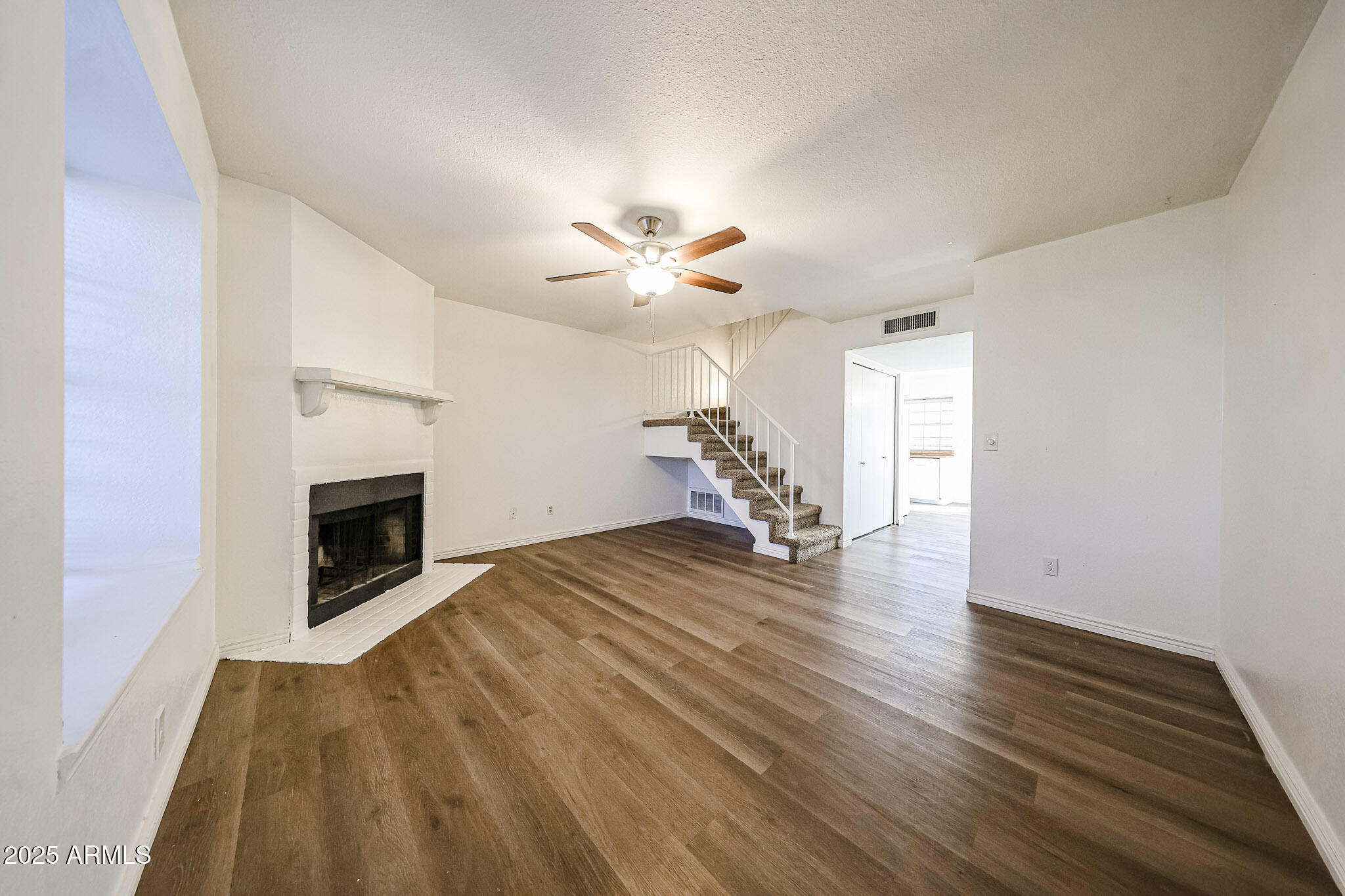 7977 West Wacker Road, Unit 245 Peoria, AZ 85381 - Photo 3 of 42 a view of a livingroom with a fireplace a chandelier and wooden floor