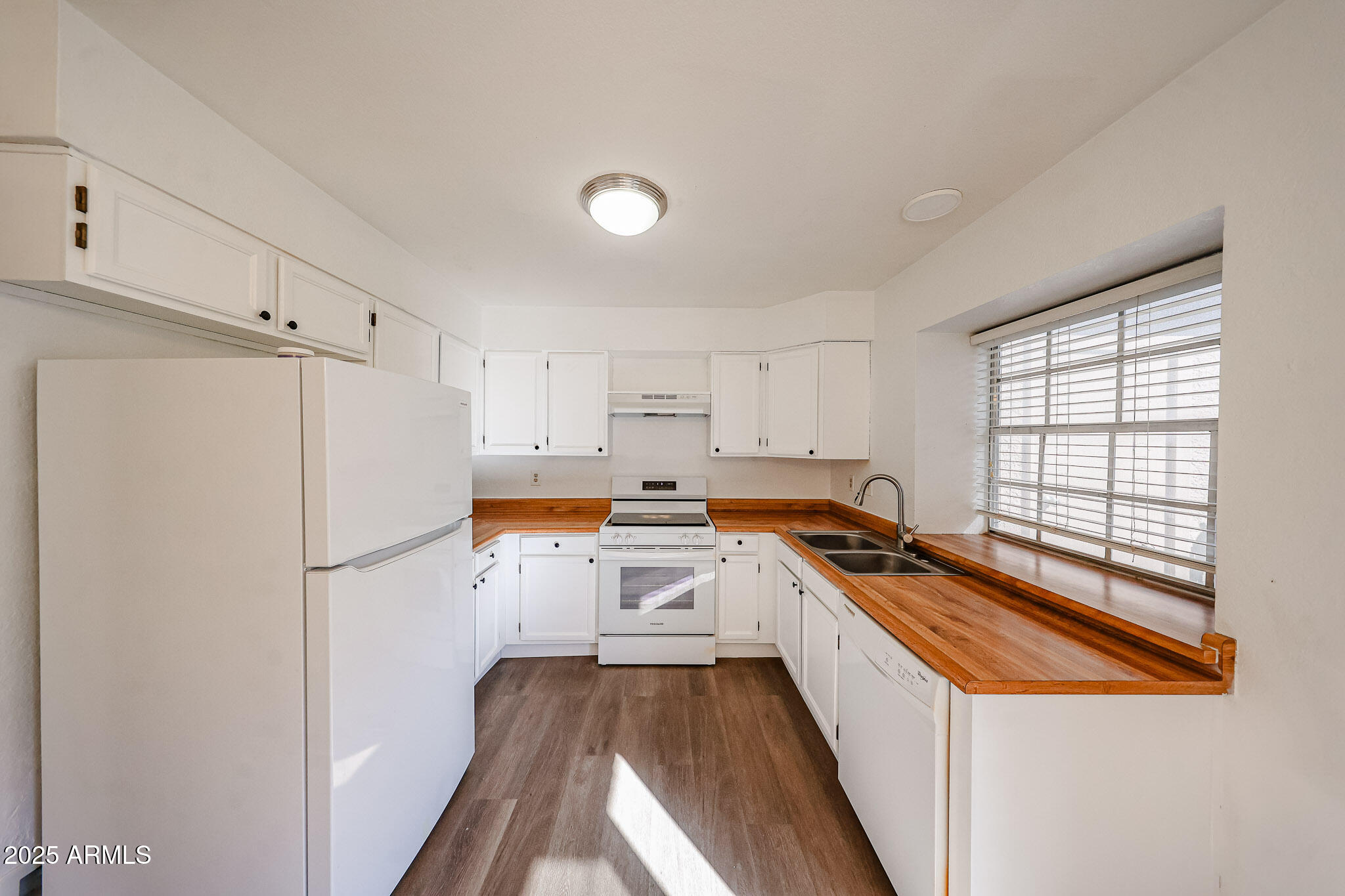 7977 West Wacker Road, Unit 245 Peoria, AZ 85381 - Photo 7 of 42 a kitchen with a refrigerator a stove and white cabinets