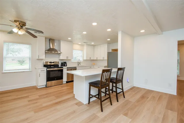 a kitchen with a table chairs microwave and cabinets