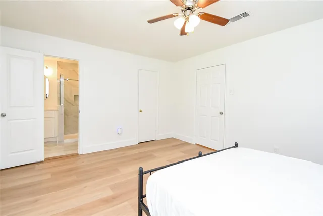 a bedroom with a bed and a chandelier fan
