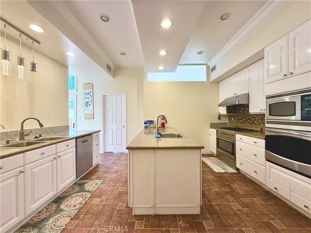 a kitchen with granite countertop a sink and cabinets