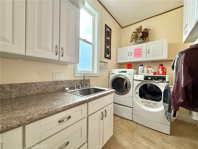 a utility room with sink dryer and washer