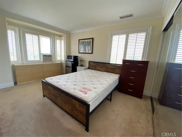 a bed sitting in a bedroom next to a window