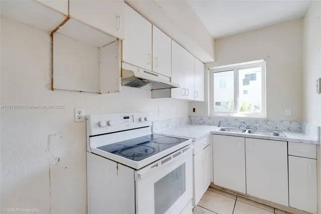 a kitchen with sink stove and cabinets