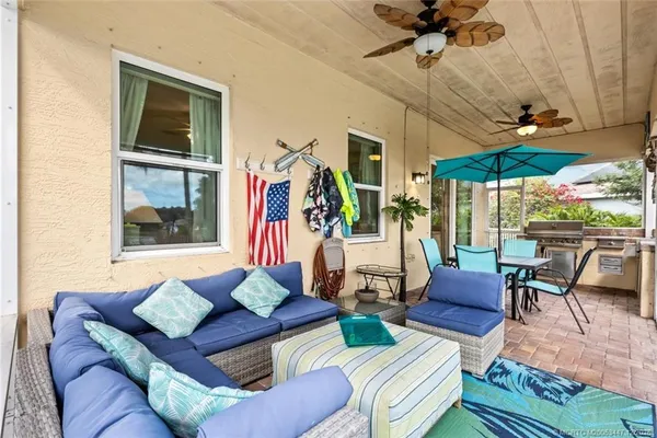 a living room with patio furniture and a floor to ceiling window