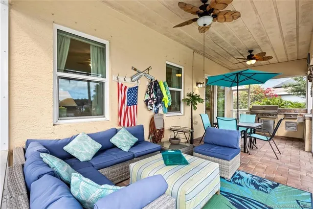 a living room with patio furniture and a floor to ceiling window