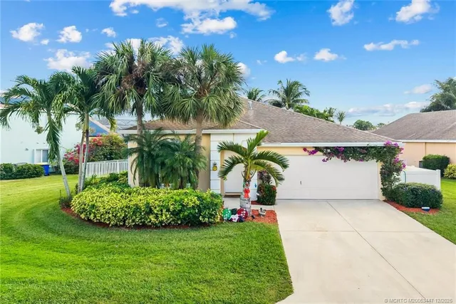 a front view of a house with a yard and trees