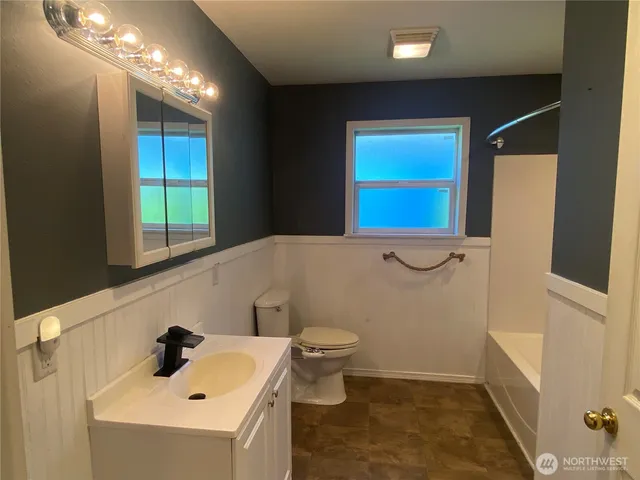 a bathroom with a sink a toilet and mirror