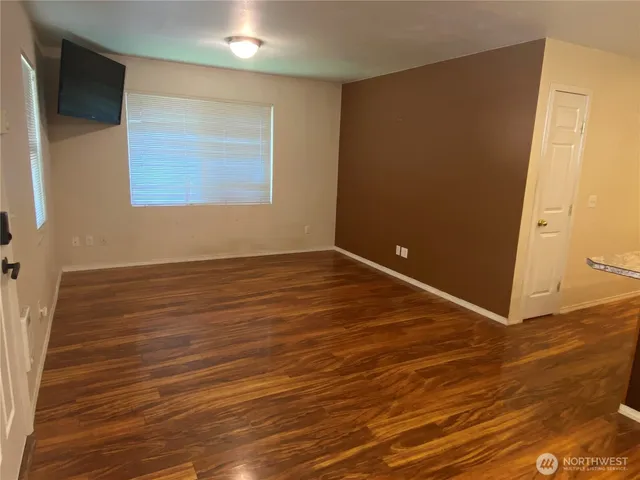 a view of an empty room with wooden floor