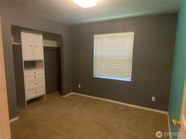 an empty room with closet and window