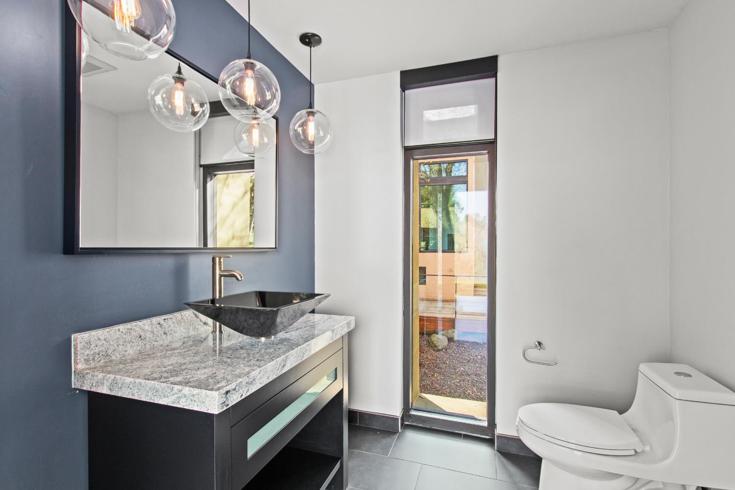 12100 Horseshoe Road Oakdale, CA 95361 - Photo 31 of 77 a bathroom with a granite countertop sink vanity and a mirror