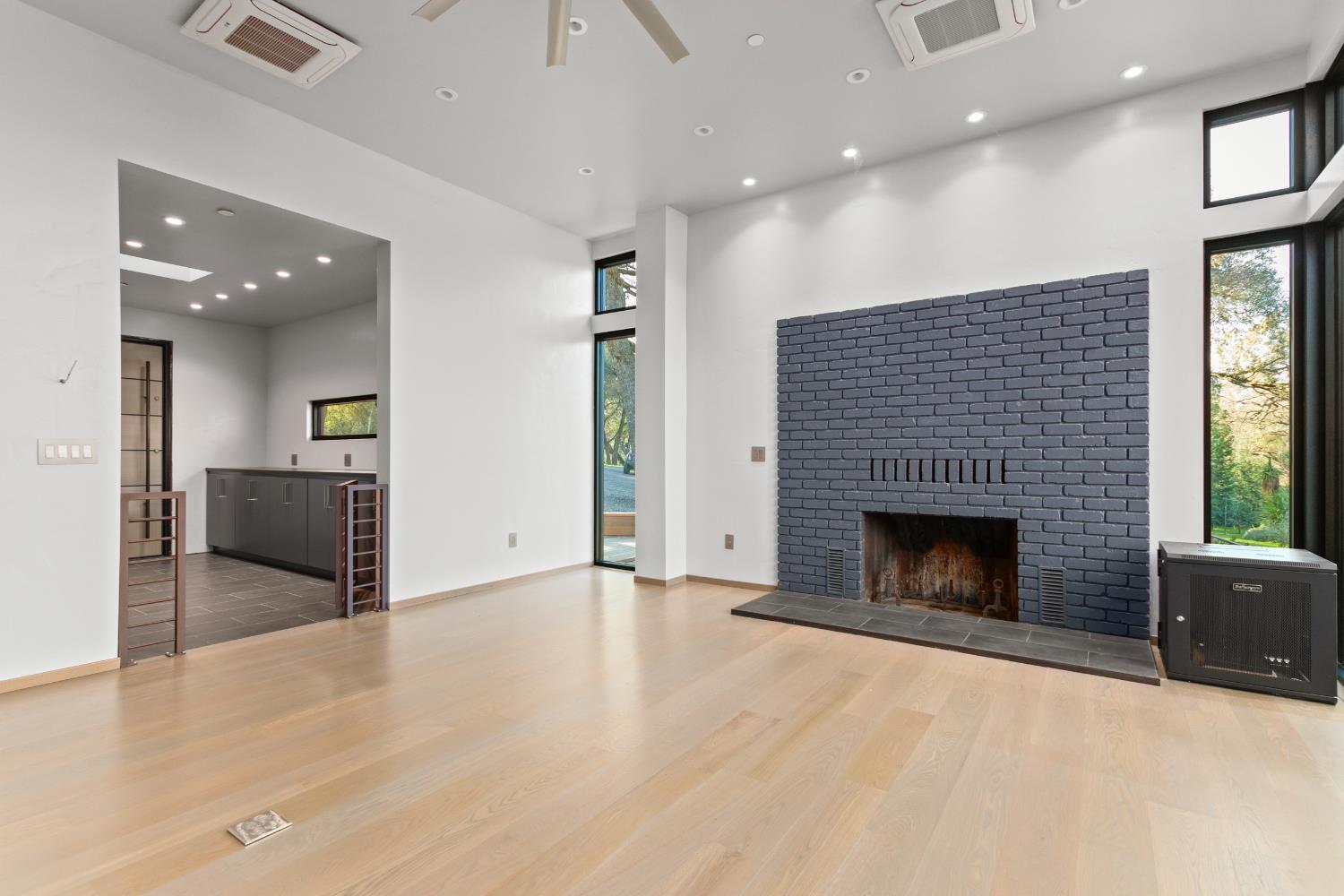 12100 Horseshoe Road Oakdale, CA 95361 - Photo 62 of 77 an empty room with wooden floor a fireplace and windows