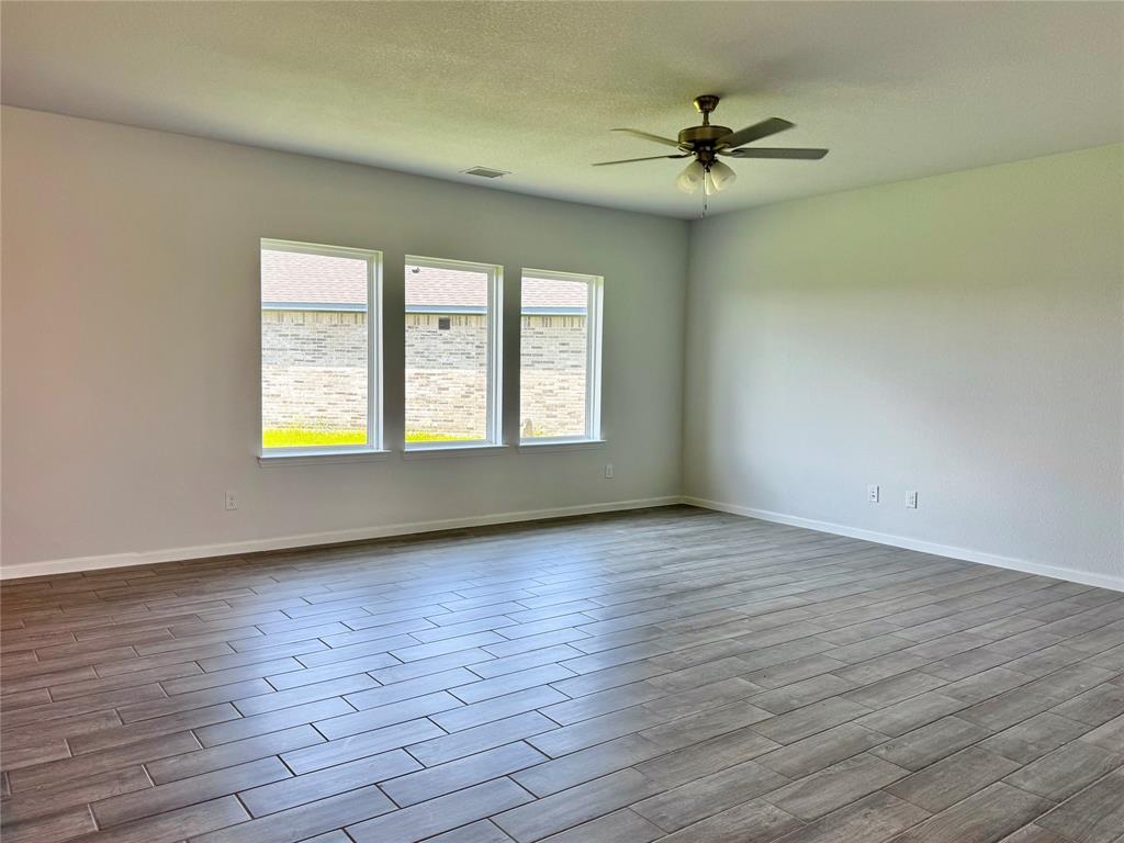1919 Aleia Cove Sherman, TX 75092 - Photo 4 of 32 a view of an empty room with a window and wooden floor