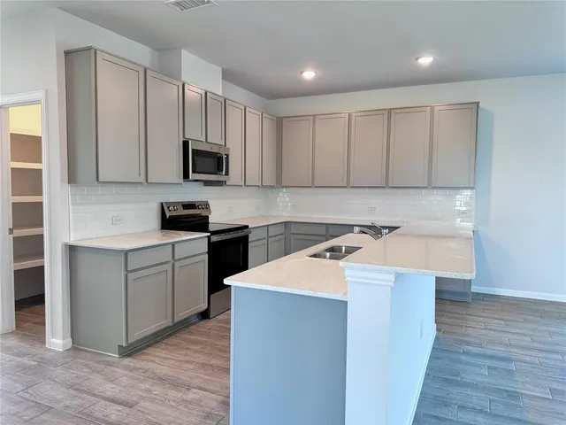a kitchen with a sink a stove and cabinets