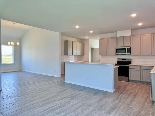 a kitchen with granite countertop a stove top oven and cabinets