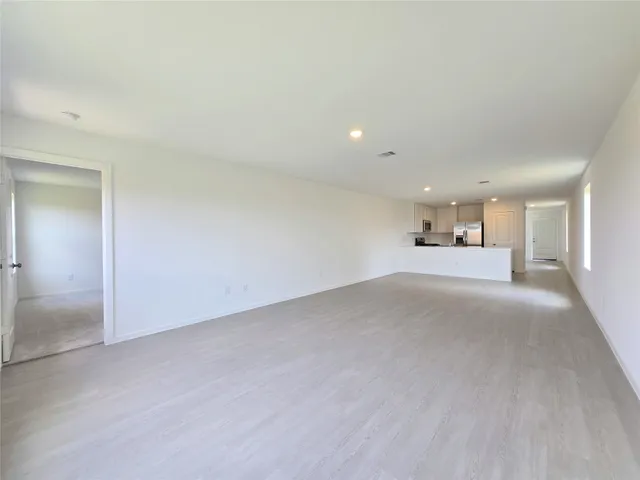 a view of empty room with a kitchen