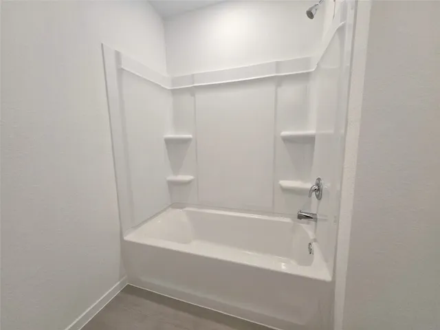 a white bath tub sitting next to a white sink and vanity
