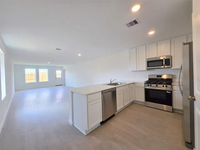 a large kitchen with cabinets and stainless steel appliances