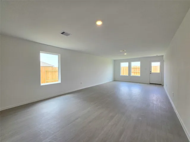 a view of empty room with window and wooden floor