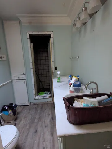 a bathroom with a sink a toilet a mirror and shower