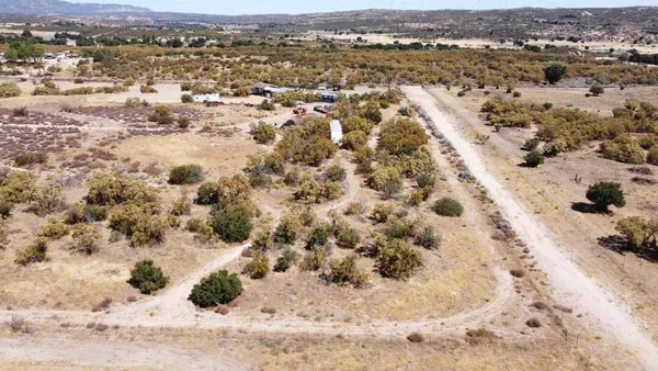 an aerial view of house with yard and mountain view in back