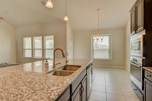 a kitchen with a sink a counter top space cabinets a stove and a window