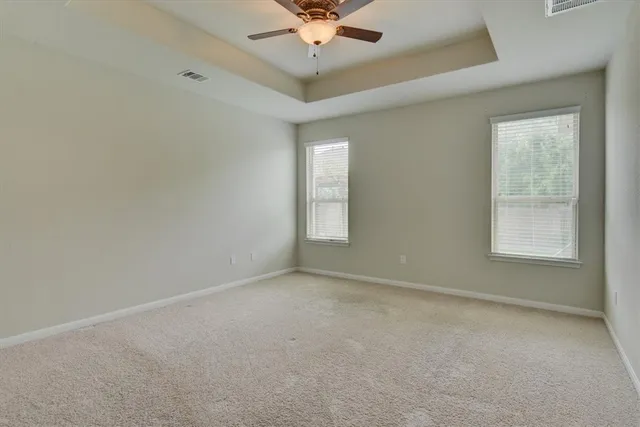 an empty room with a window and a ceiling fan