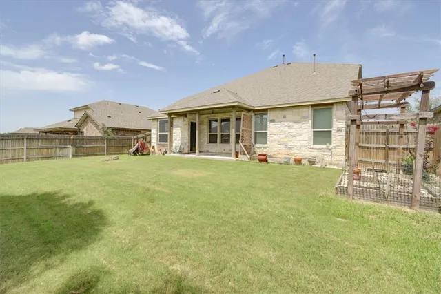 a view of a house with a big yard and large trees