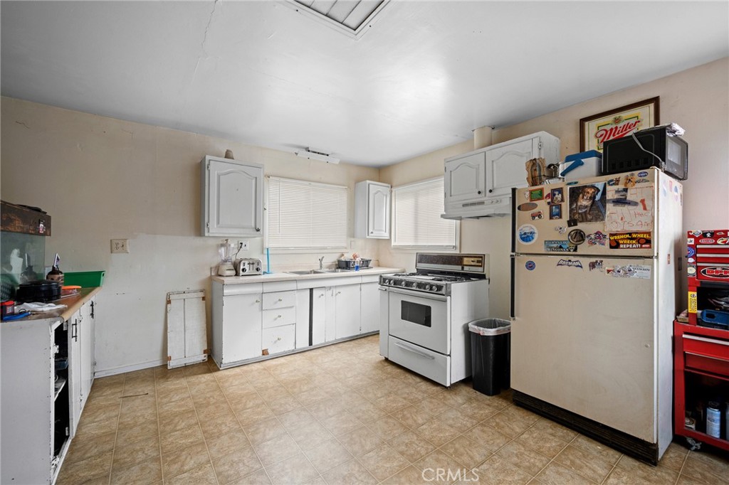 7025 Day Street Tujunga, CA 91042 - Photo 23 of 37 a kitchen with white cabinets and white appliances