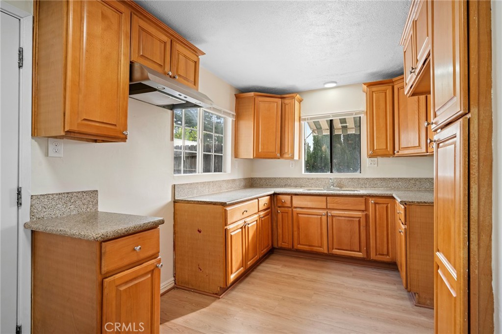 7025 Day Street Tujunga, CA 91042 - Photo 7 of 28 a kitchen with stainless steel appliances granite countertop wooden cabinets a sink and dishwasher a refrigerator with wooden cabinets