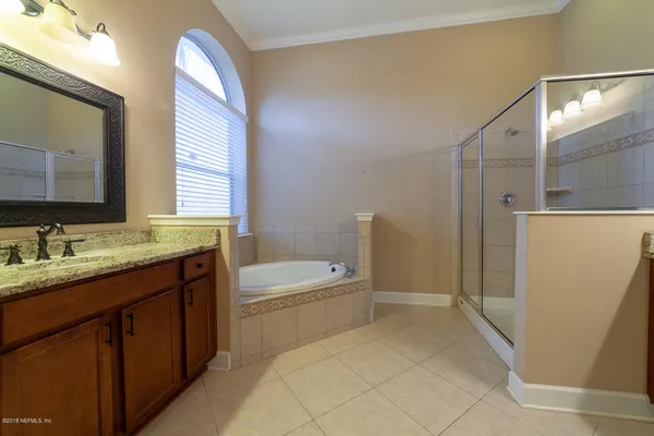 a bathroom with a tub sink and mirror