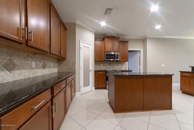 a kitchen with stainless steel appliances granite countertop a stove a microwave and a refrigerator