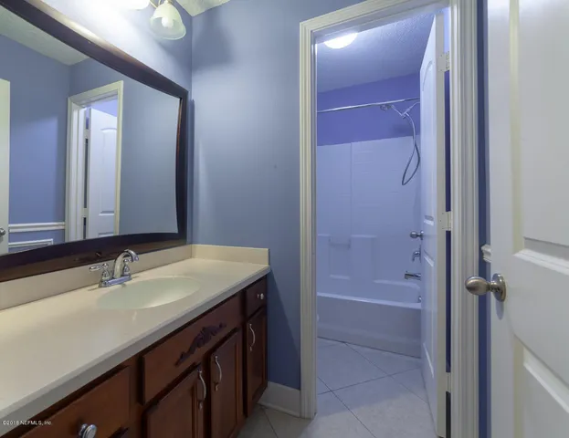 a bathroom with a sink a mirror and a bathtub