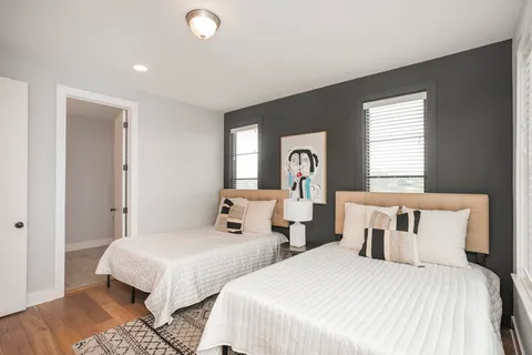 a bedroom with two beds and a large window