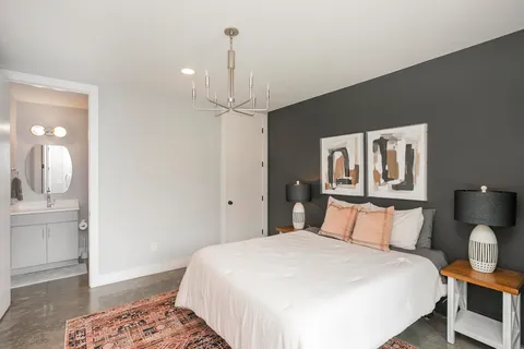 a bedroom with a bed and painting on the wall