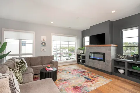 a living room with furniture a flat screen tv and a fireplace