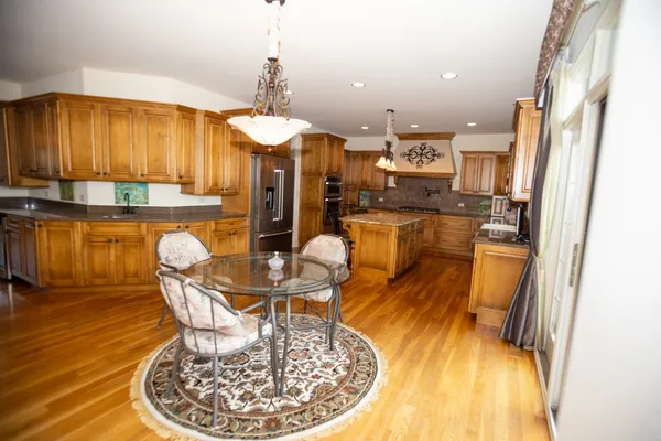 a dining room with furniture a chandelier and wooden floor