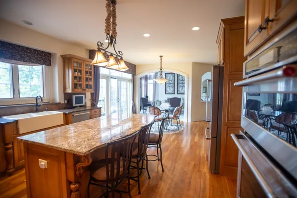 a dining room with wooden floor a chandelier a wooden table and chairs