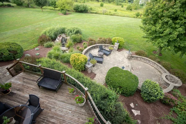 an aerial view of a house with garden space lake and outdoor seating