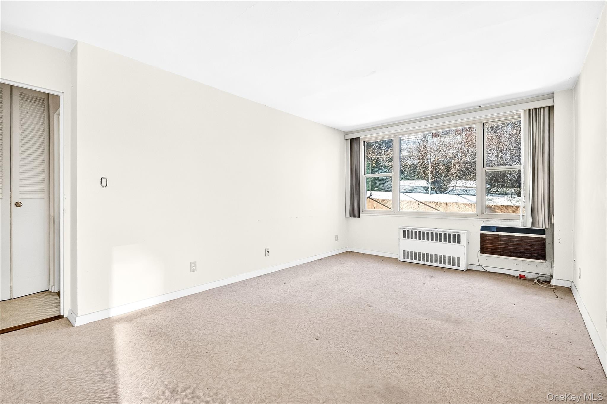 12 Old Mamaroneck Road, Unit 2G White Plains, NY 10605 - Photo 25 of 38 an empty room with a fireplace and large windows