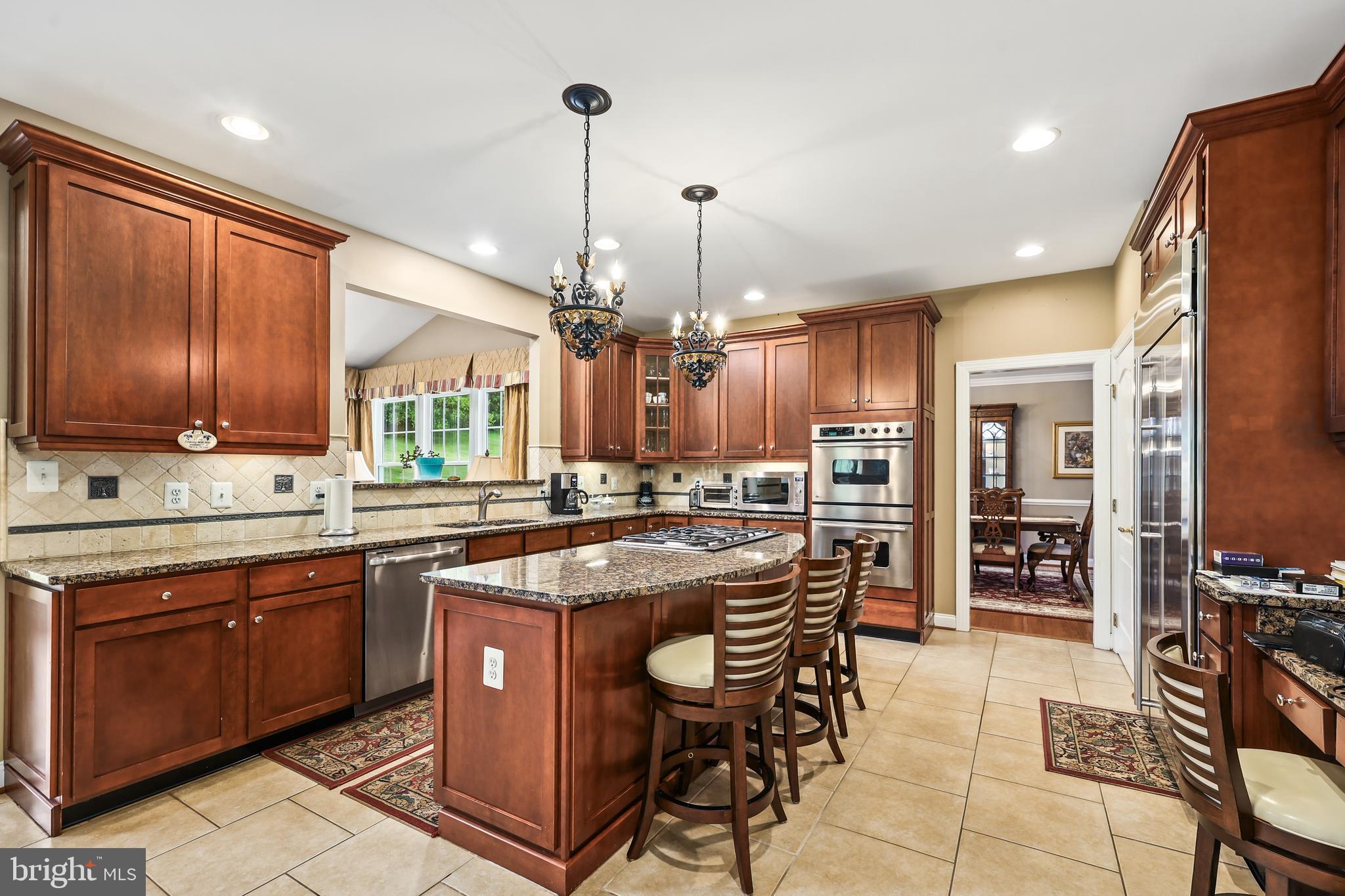 40890 Beechnut Road Leesburg, VA 20175 - Photo 17 of 65 a kitchen with stainless steel appliances granite countertop wooden cabinets a stove a sink a dining table and chairs
