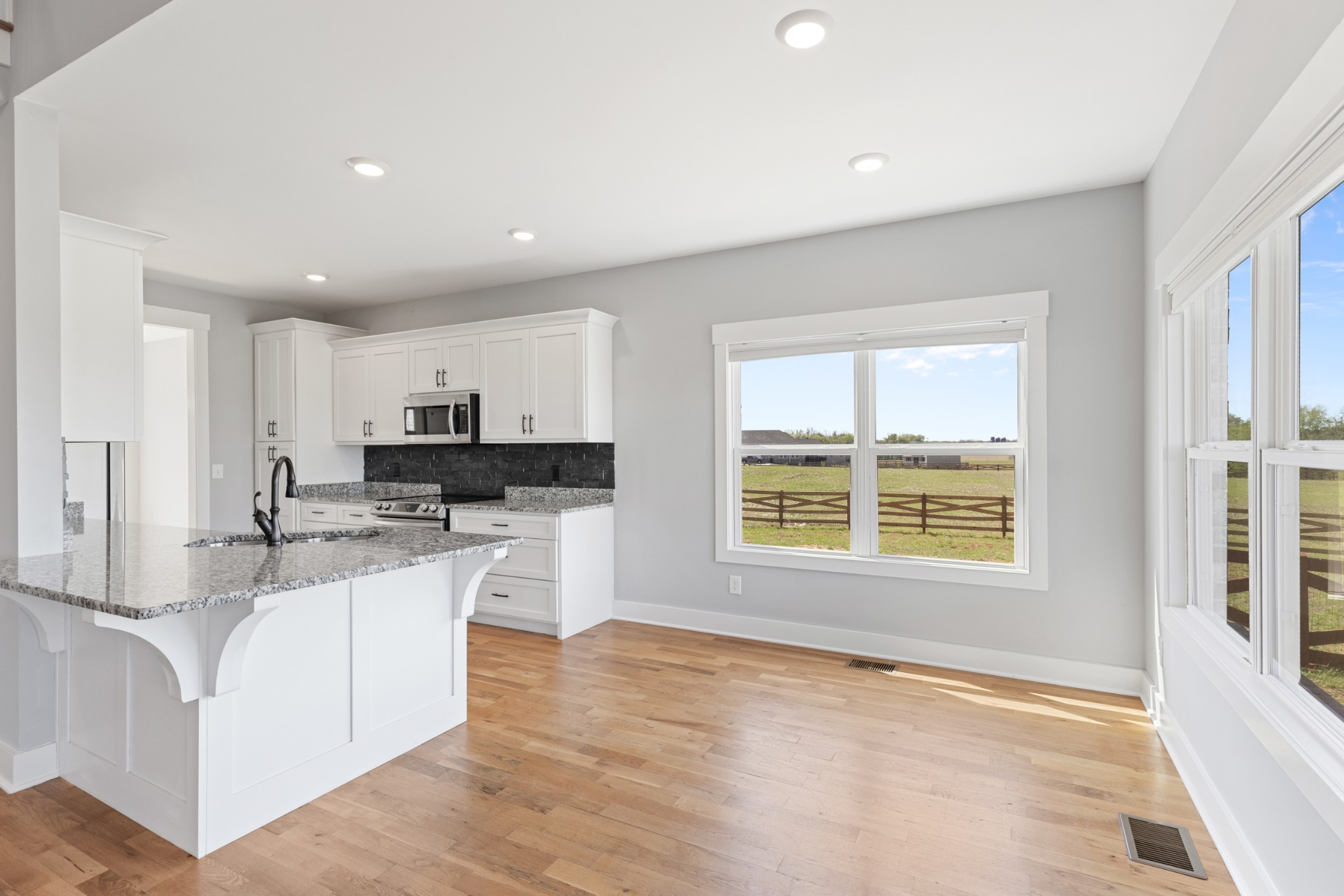 5450 Highway 431 Springfield, TN 37172 - Photo 16 of 54 a kitchen with stainless steel appliances granite countertop a stove a sink a refrigerator and white cabinets with wooden floor