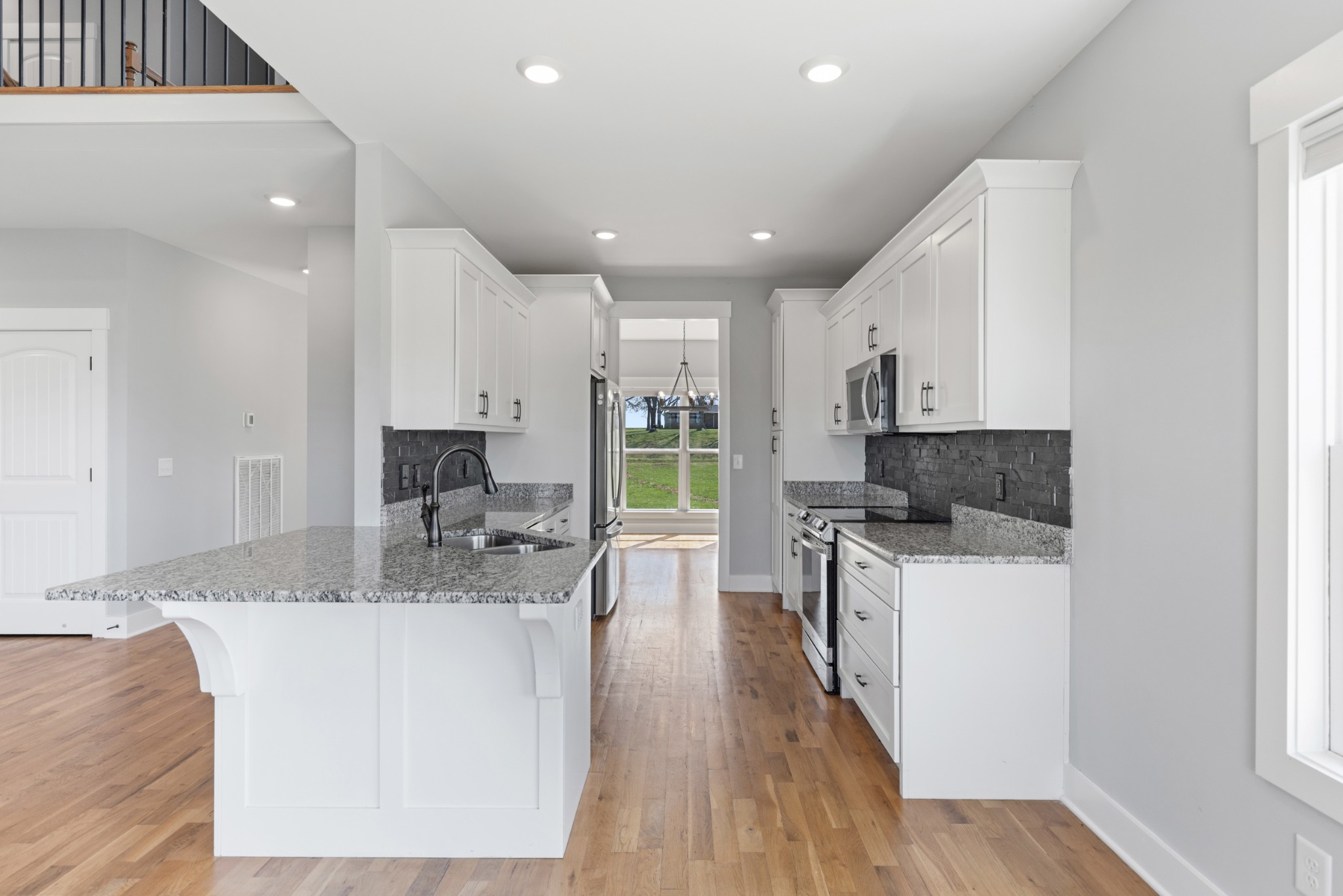 5450 Highway 431 Springfield, TN 37172 - Photo 18 of 54 a large kitchen with stainless steel appliances granite countertop a stove a sink a refrigerator and white cabinets with wooden floor