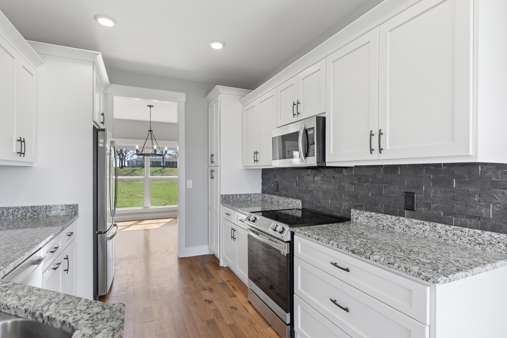 5450 Highway 431 Springfield, TN 37172 - Photo 20 of 54 a kitchen with granite countertop a stove oven and white cabinets