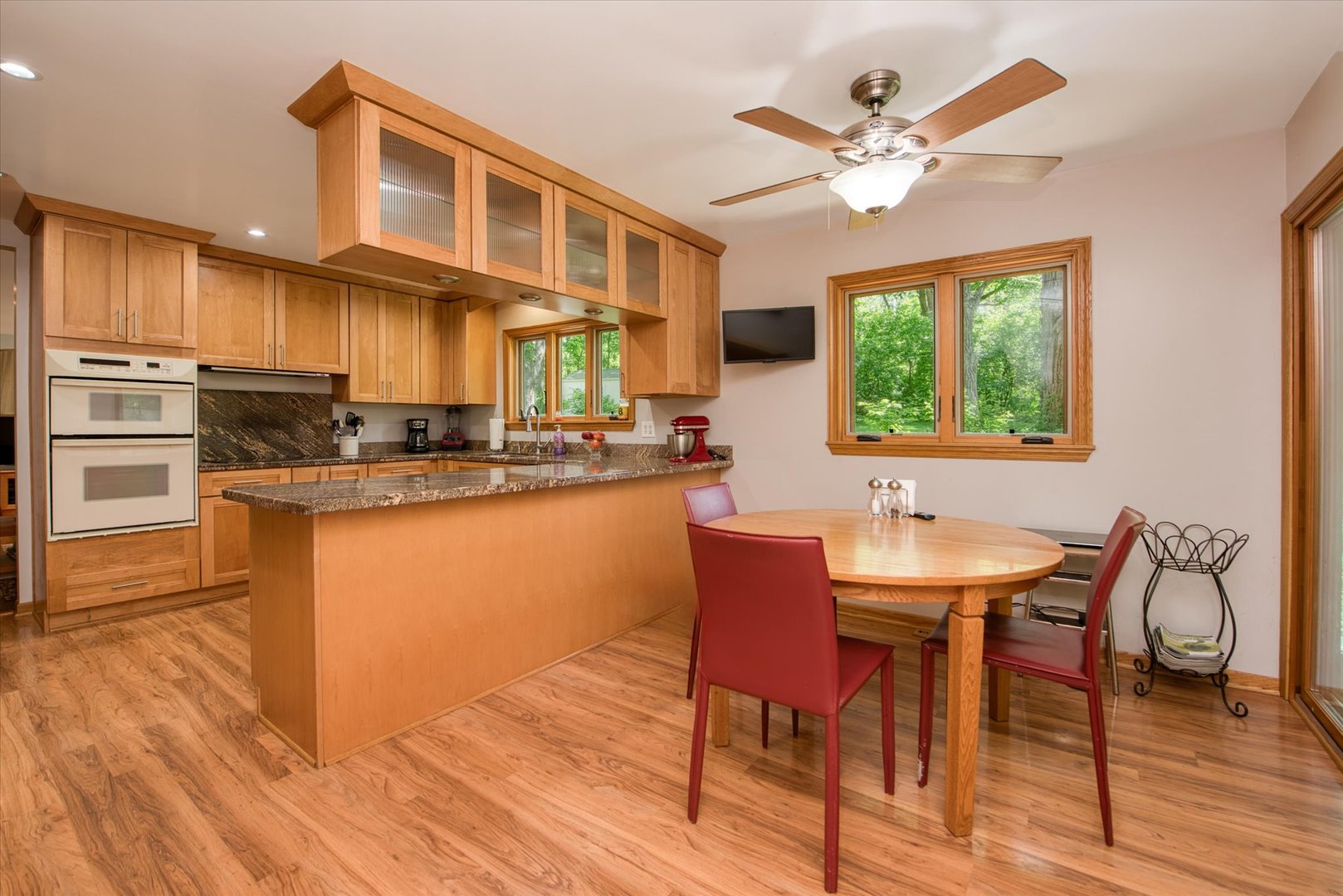 1196 Nottingham Lane Elgin, IL 60120 - Photo 17 of 45 a kitchen with stainless steel appliances kitchen island granite countertop a table chairs a sink dishwasher and cabinets with wooden floor