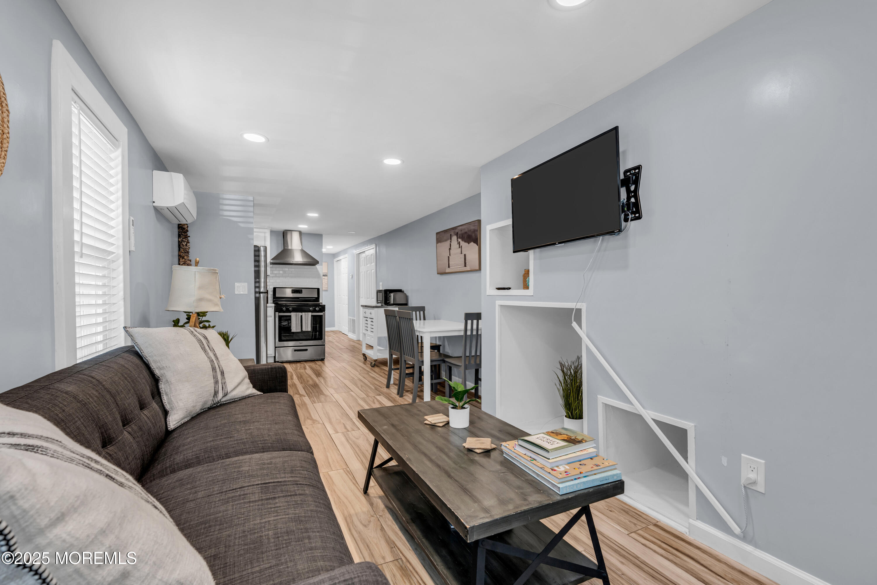 68 Clark Avenue, Unit 1E Ocean Grove, NJ 07756 - Photo 2 of 13 a living room with furniture a flat screen tv and a fireplace