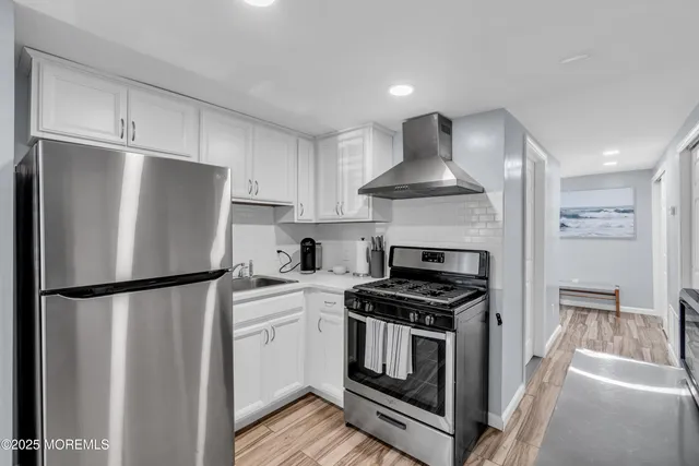 a kitchen with a refrigerator a stove and cabinets